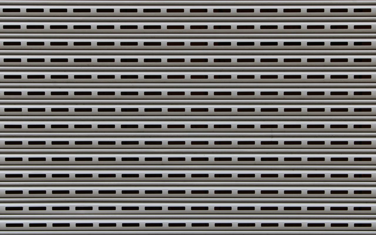 about-us-01 Close-up view of a textured metallic roll-up door showcasing repetitive horizontal patterns.